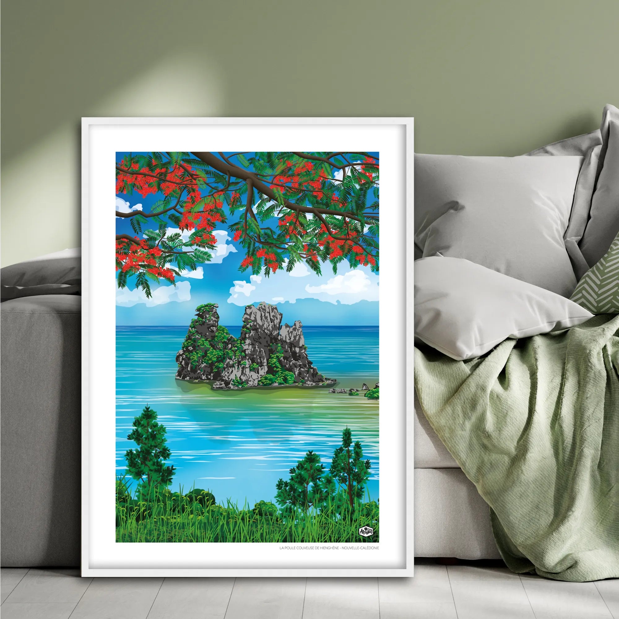 Affiche Nouvelle-Calédonie « La poule couveuse de Hienghène », format 50×70 cm avec cadre blanc, posée contre un lit dans une chambre à la décoration douce et naturelle