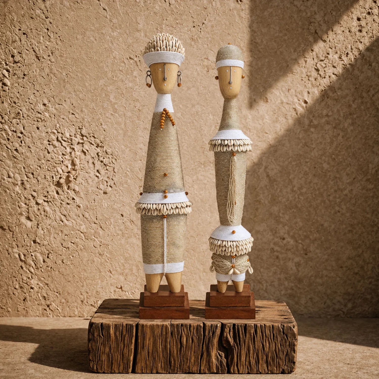 Couple de statues décoratives blanches d’inspiration Namji, en bois, perles, cordage et cauris, présenté dans une mise en scène artisanale
