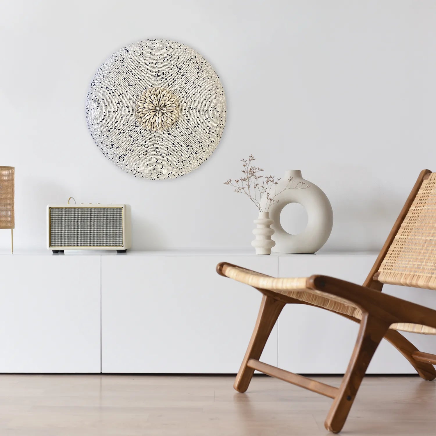 Bouclier mural perlé en bois et coquillages cauris dans un intérieur minimaliste