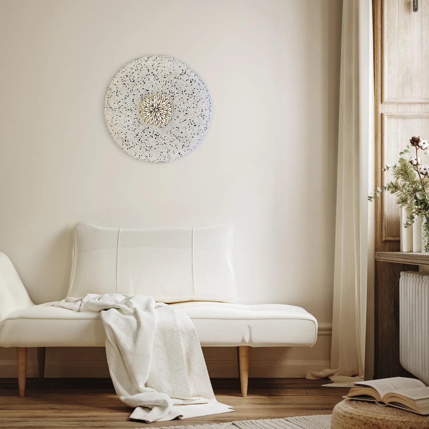 Bouclier mural en perles et cauris au-dessus d’un canapé dans un intérieur naturel